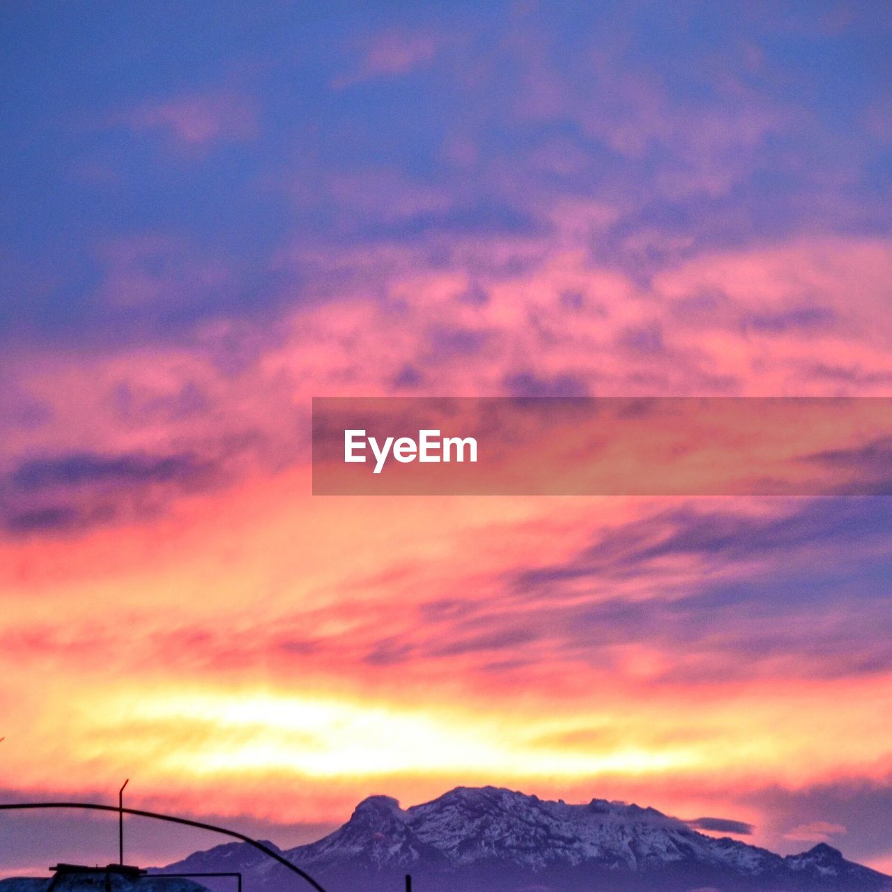 SCENIC VIEW OF MOUNTAINS AGAINST DRAMATIC SKY