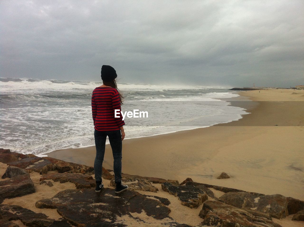 Rear view of woman standing on beach