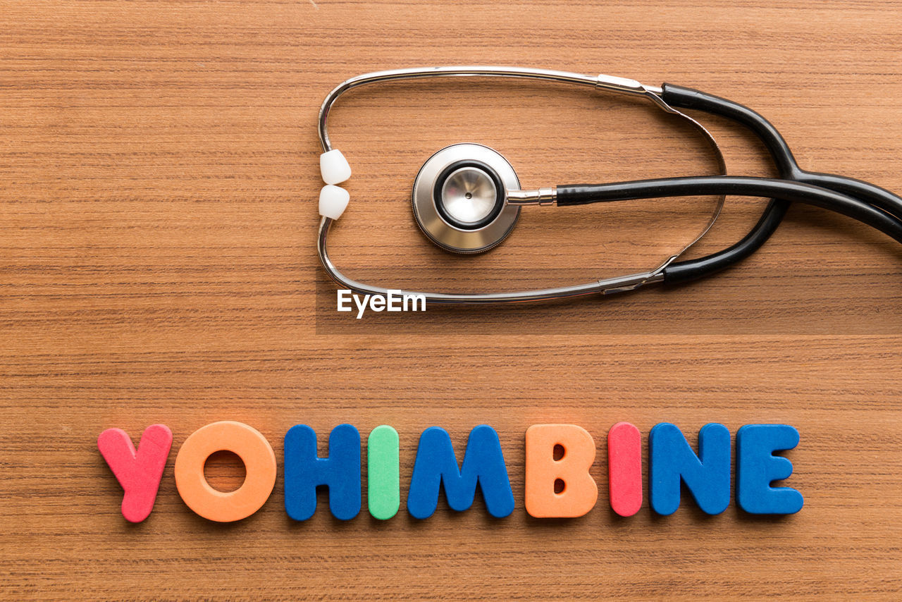 Directly above shot of stethoscope with yohimbine text on wooden table