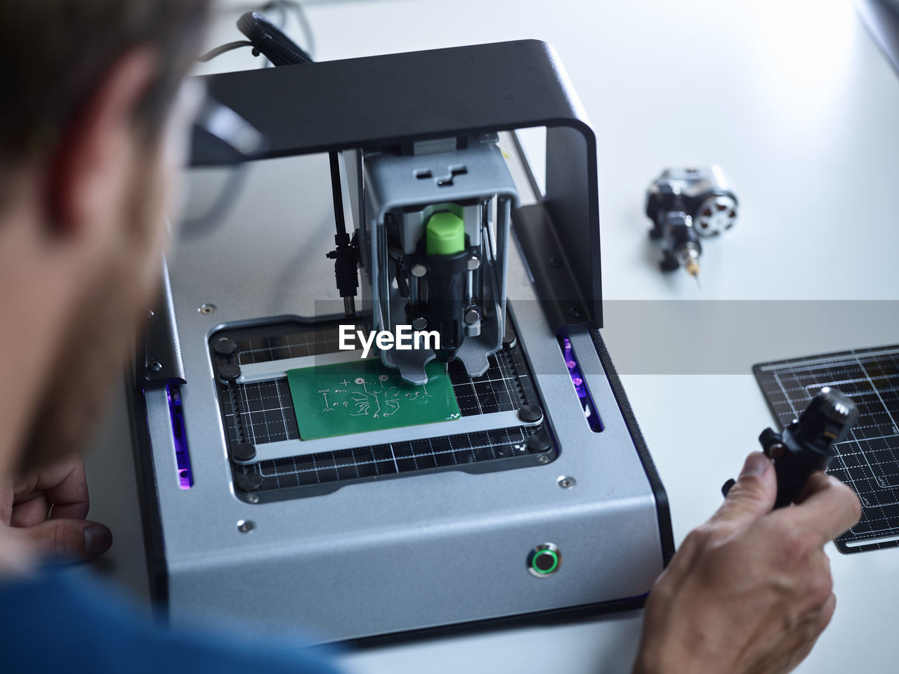 Engineer operating milling machine on circuit board in laboratory