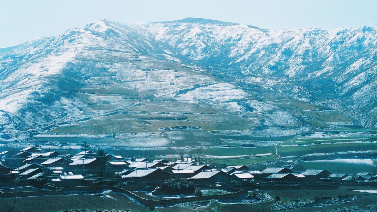 High angle view of field and mountain against sky