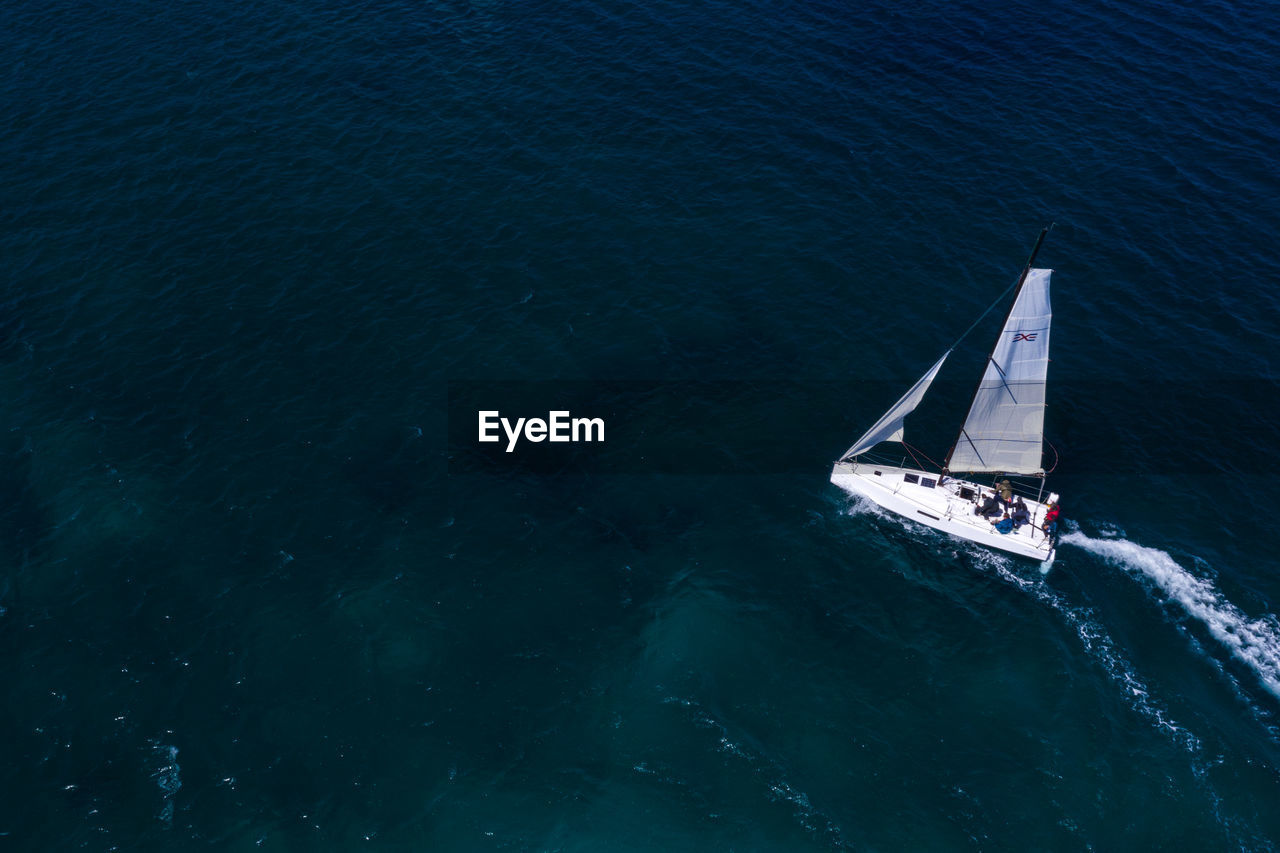 HIGH ANGLE VIEW OF SAILBOAT IN SEA