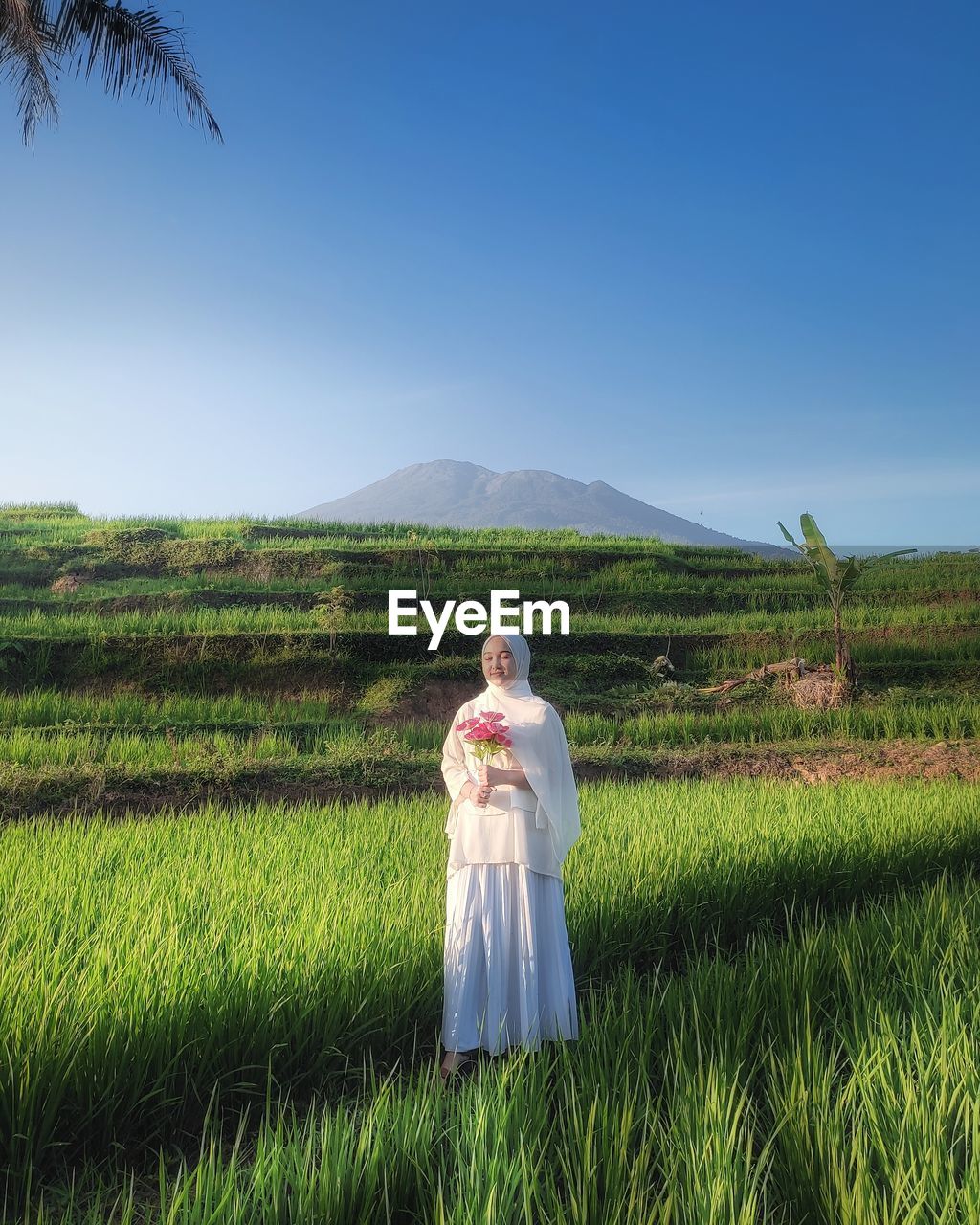 Woman standing on field against sky