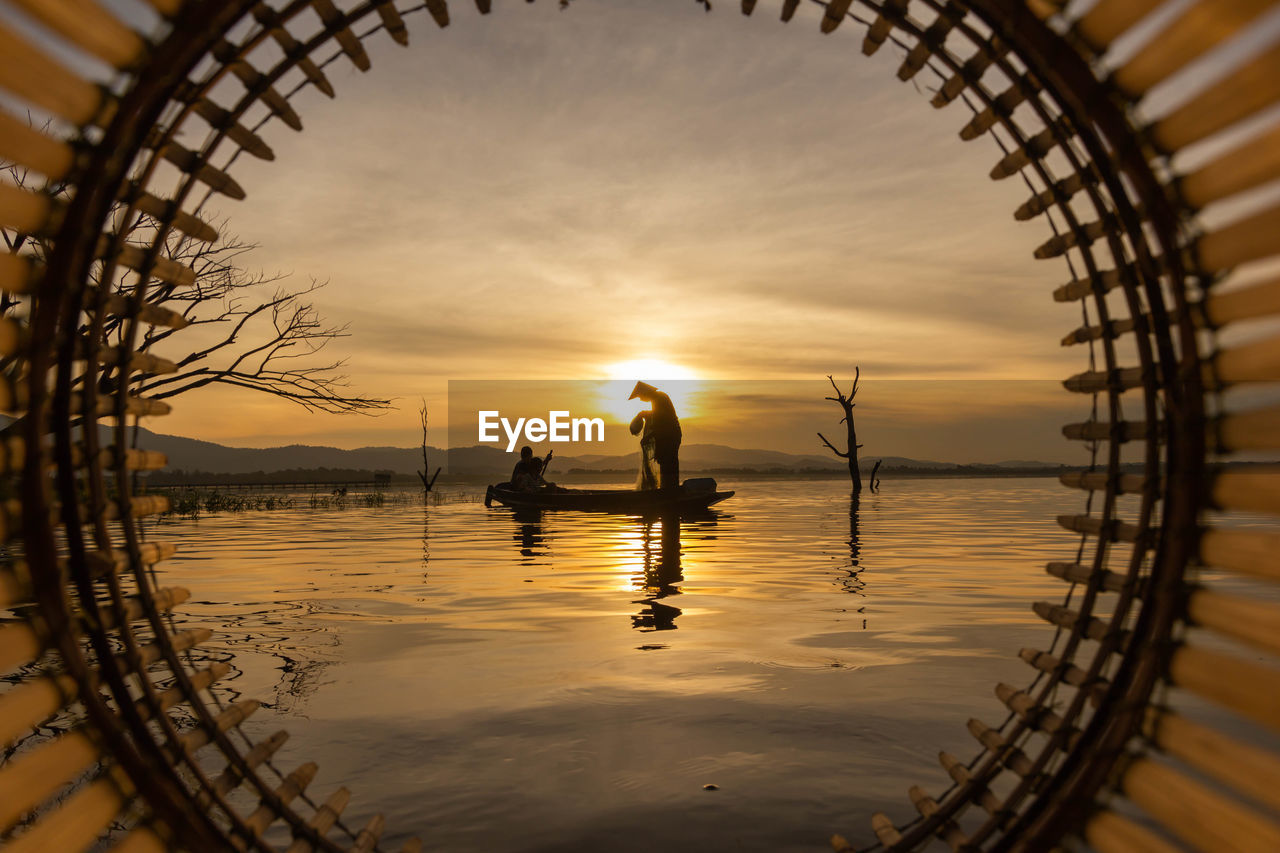 People seen through circle on boat in sea against sky