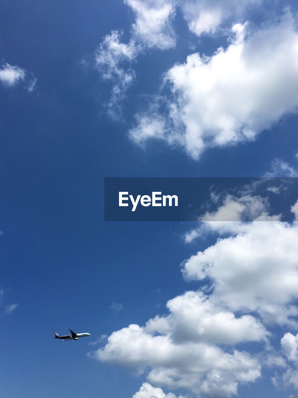 Low angle view of airplane flying in blue sky