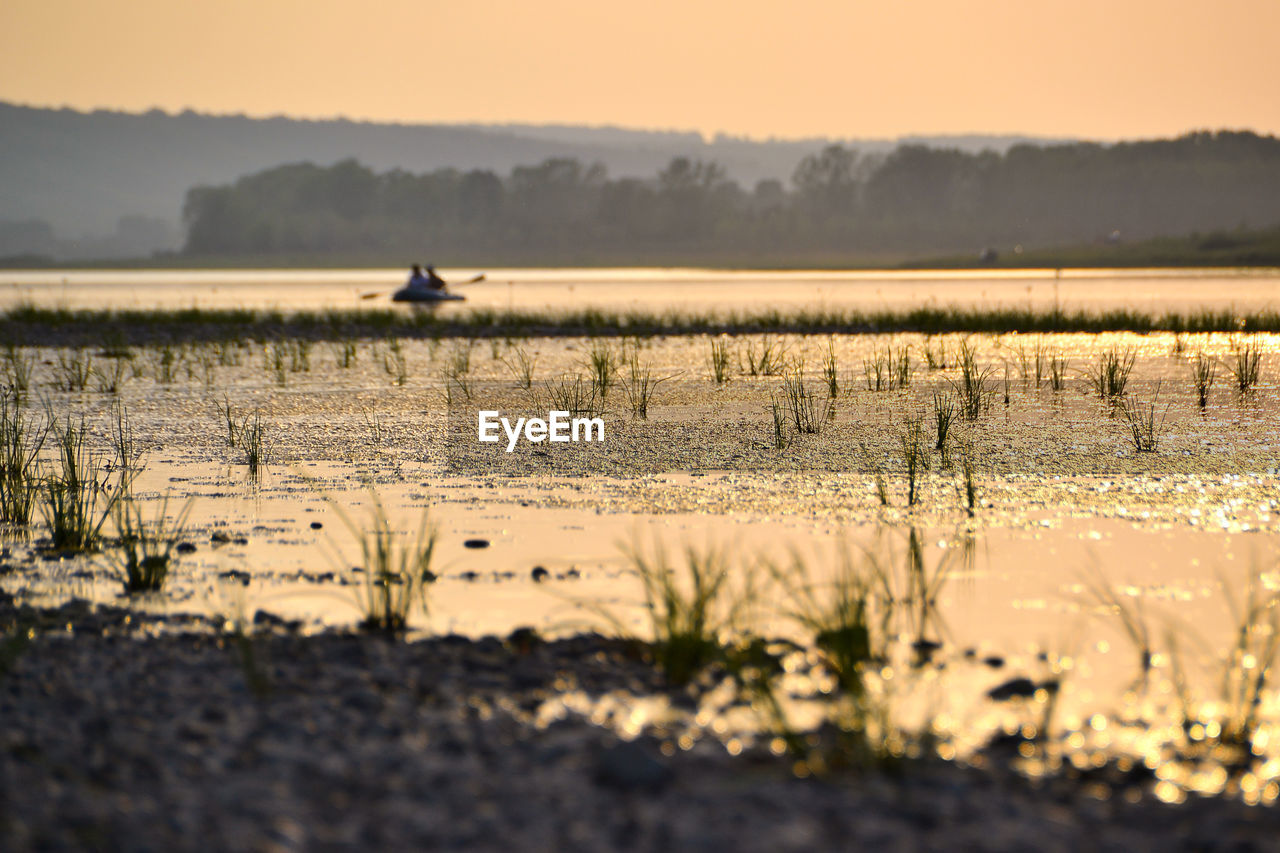 Scenic view of river against sky during sunset