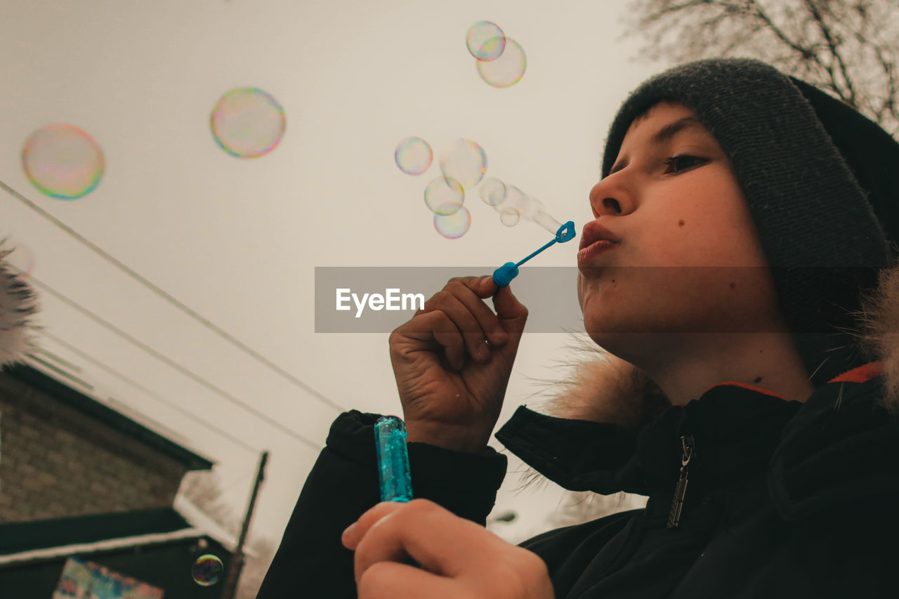 PORTRAIT OF MAN HOLDING BUBBLES IN BUBBLE