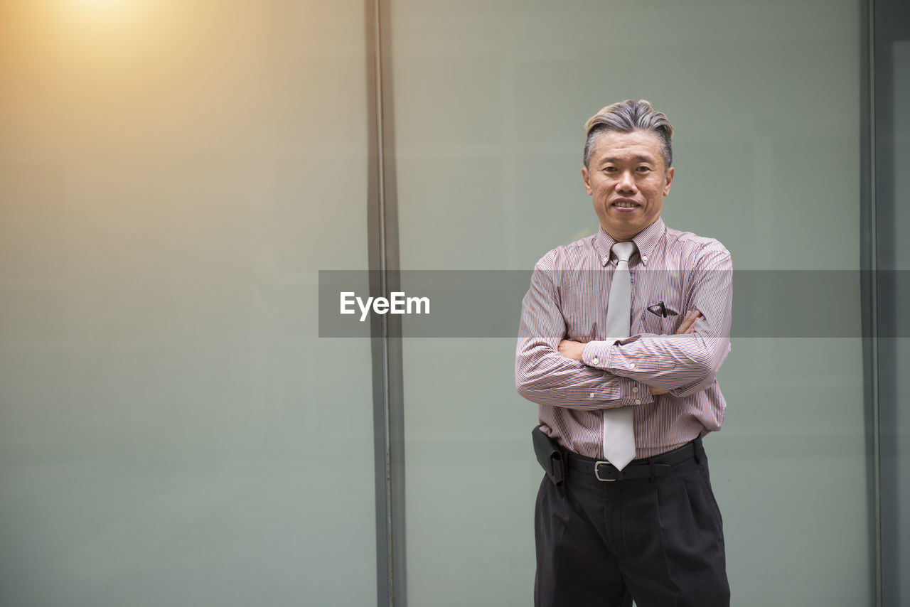 Well-dressed businessman standing against building in city 