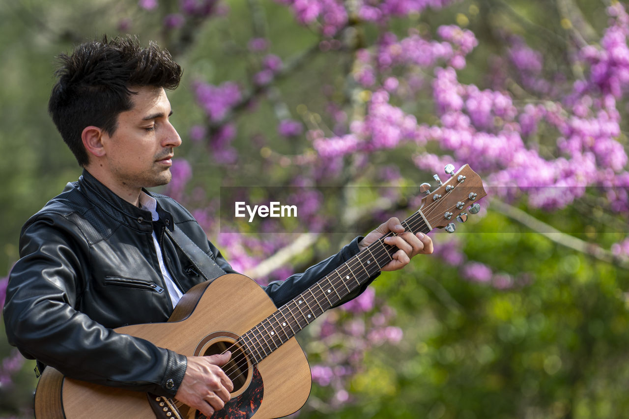 side view of young man playing guitar