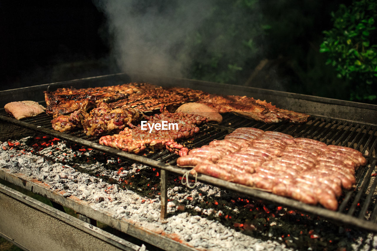 Close-up of meat on barbecue grill at night