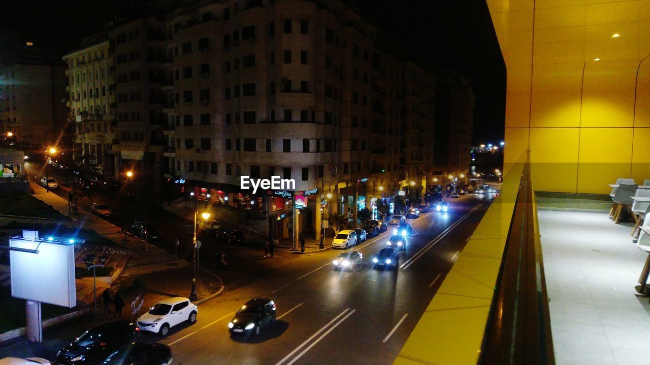 PEOPLE ON ILLUMINATED CITY STREET AT NIGHT