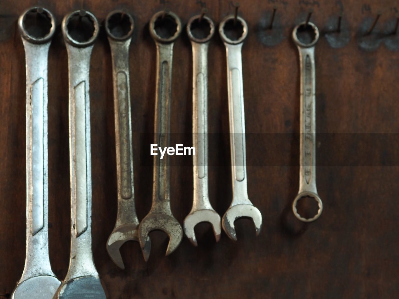 Close-up of work tools hanging side by side in workshop