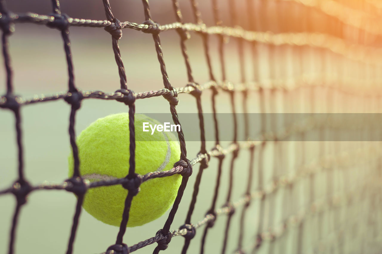 Close-up of tennis ball hitting net