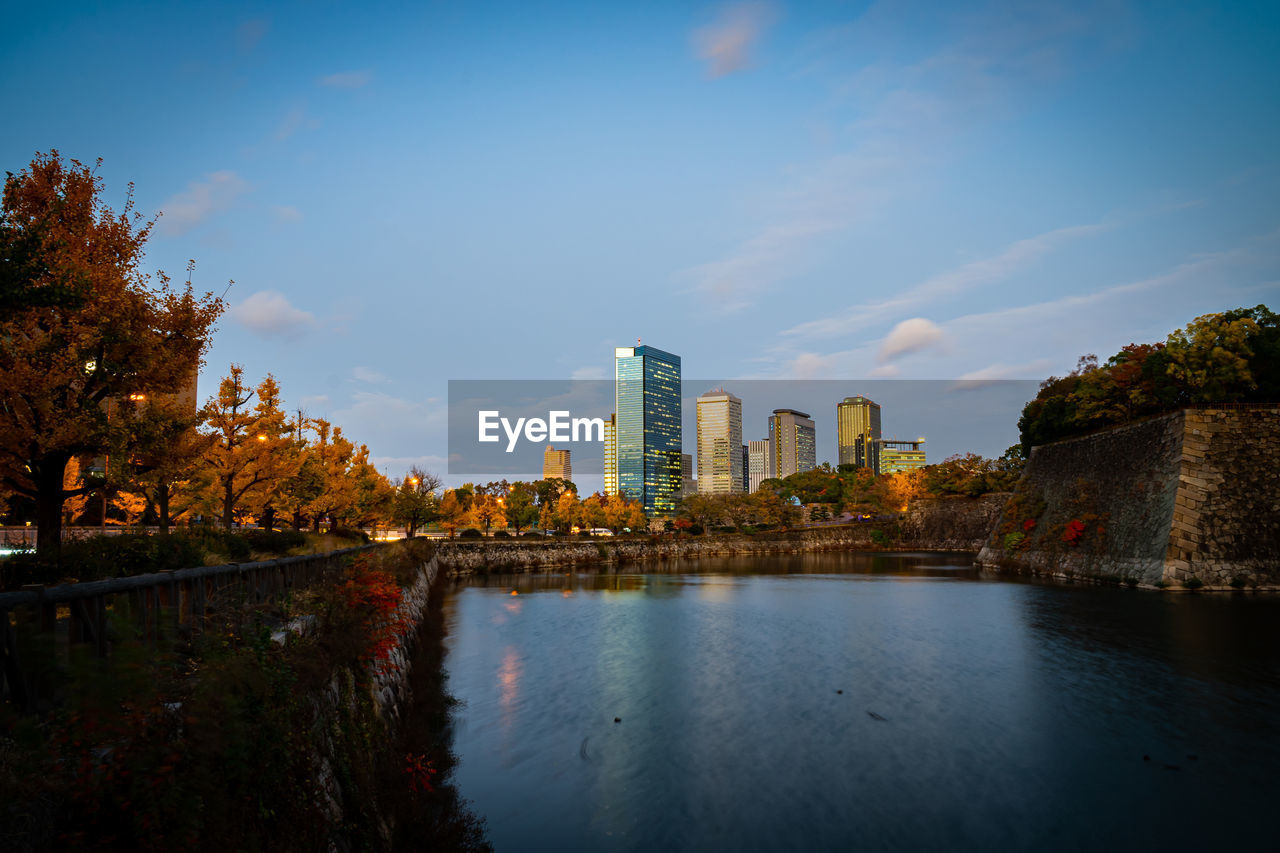 Scenic view of lake by buildings against sky