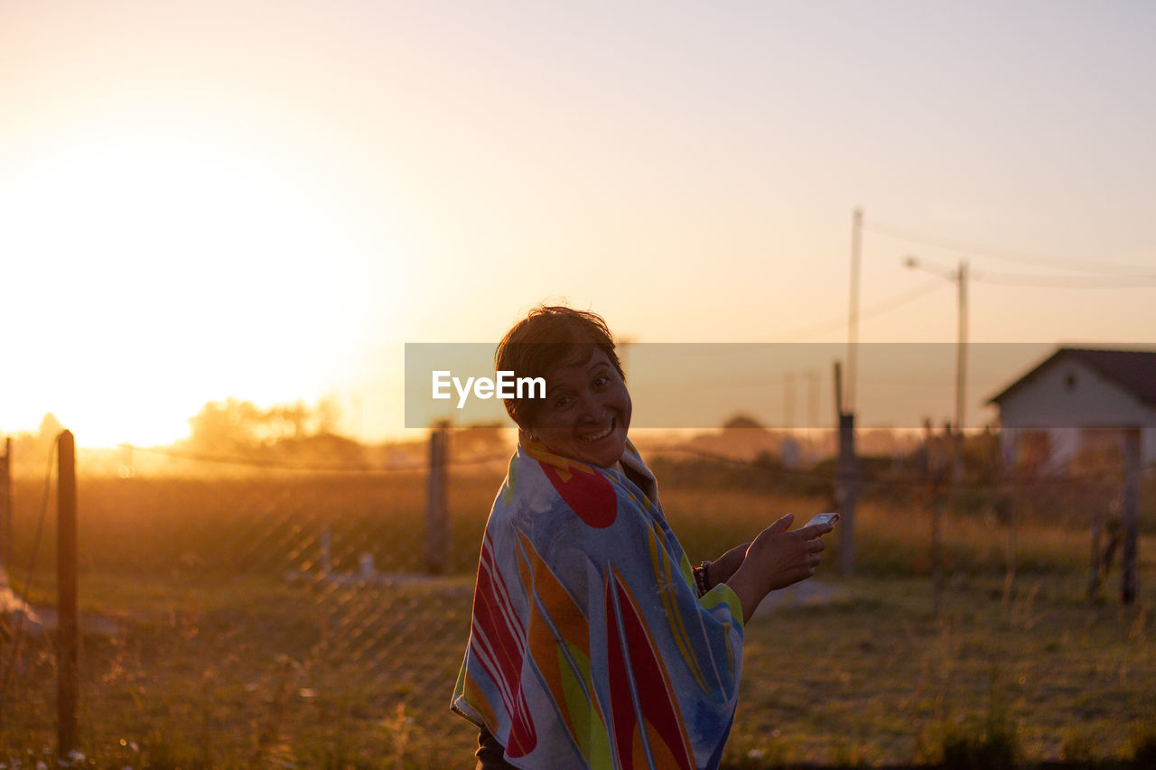 Portrait of smiling woman standing on field