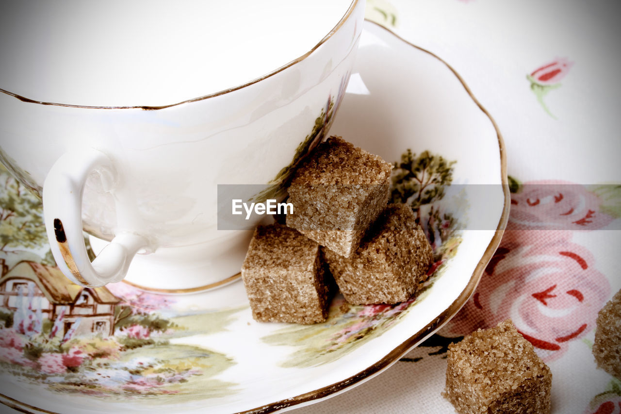 Close-up of brown sugar by cup on saucer