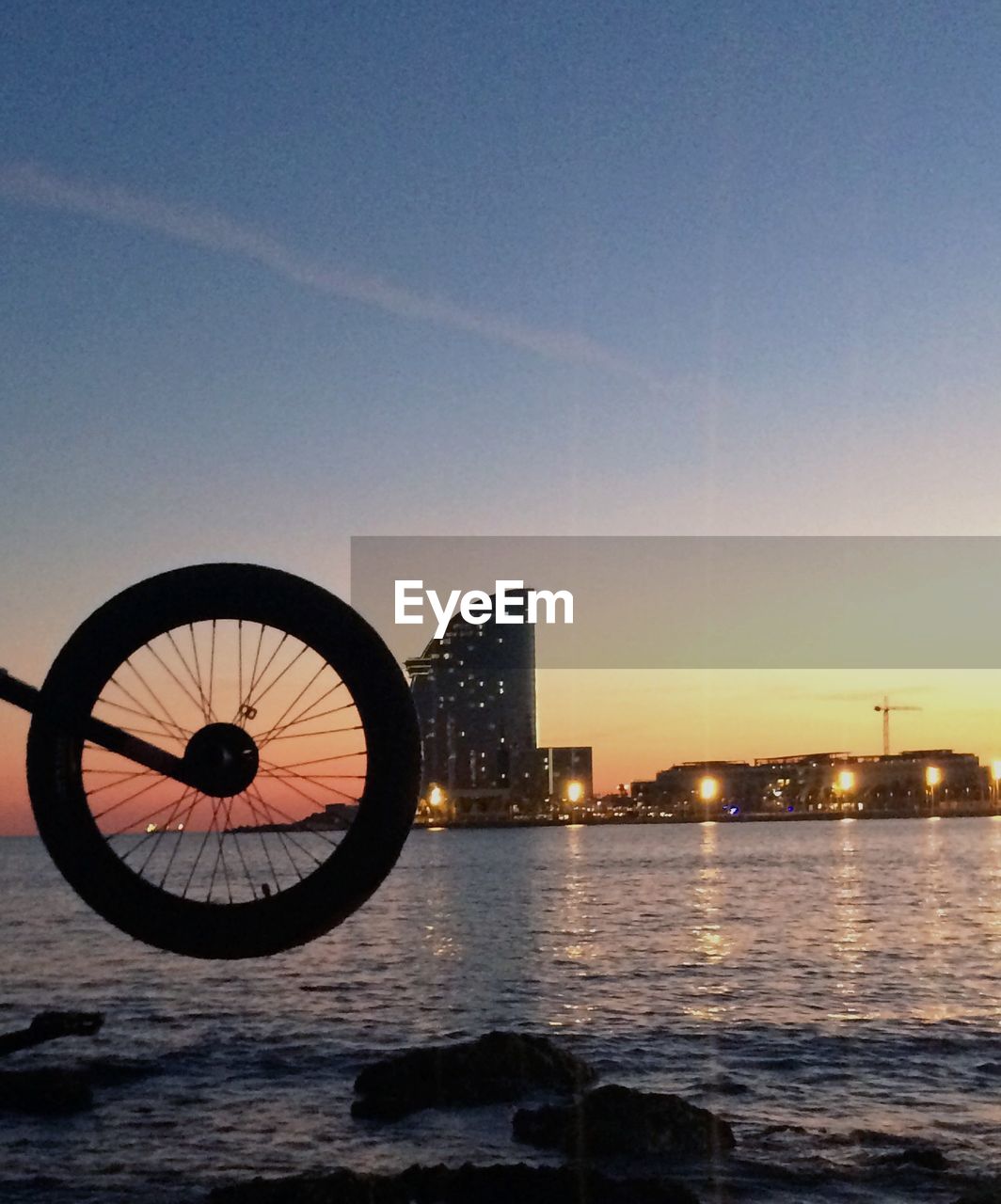 Cropped image of motorcycle at beach during sunset