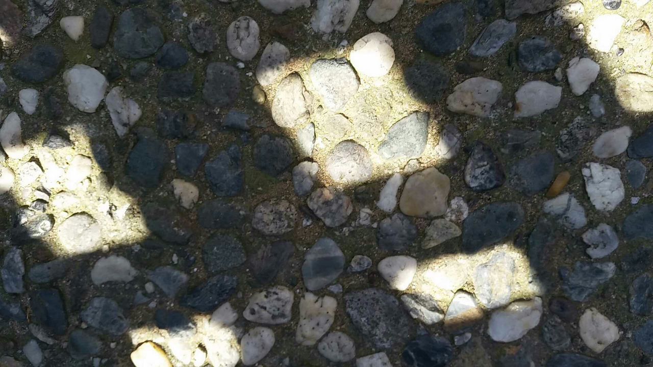 Shadow of grate on pebbles