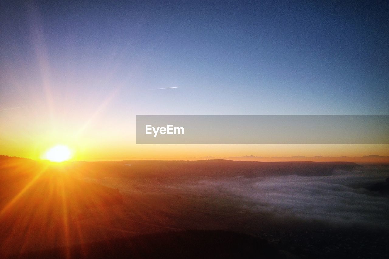 View of landscape against clear sky during sunset