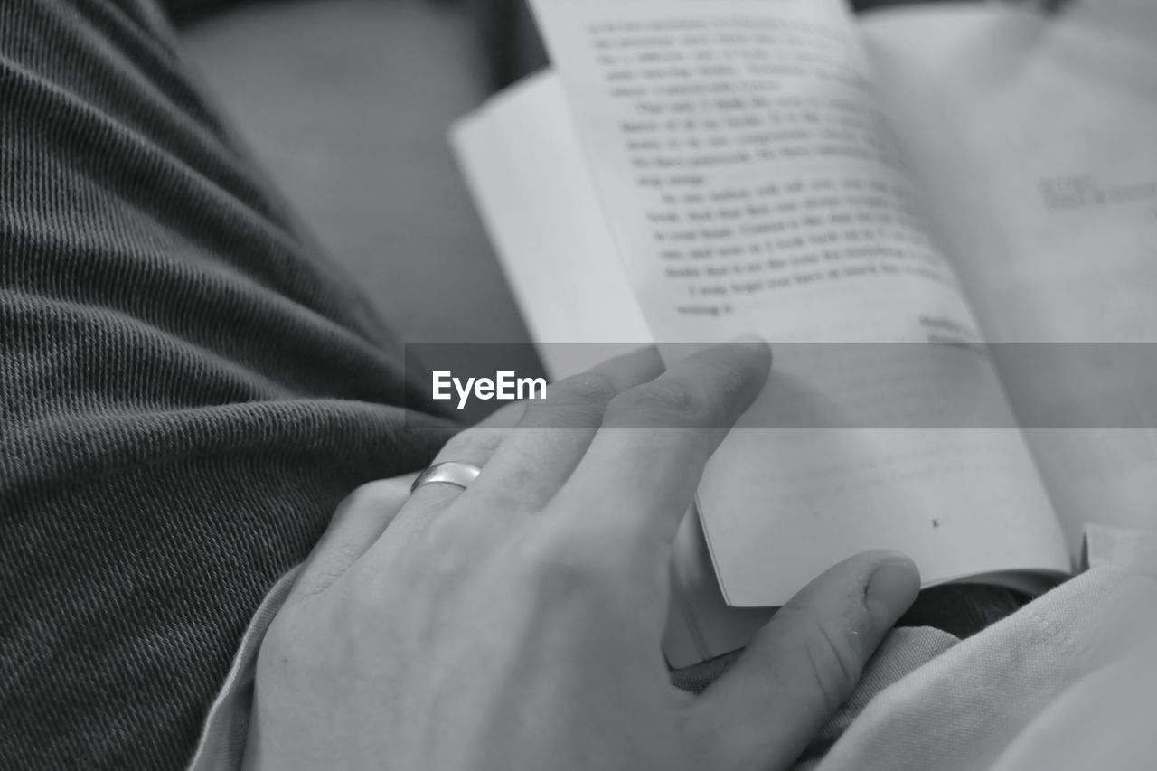 Cropped hand of person reading book