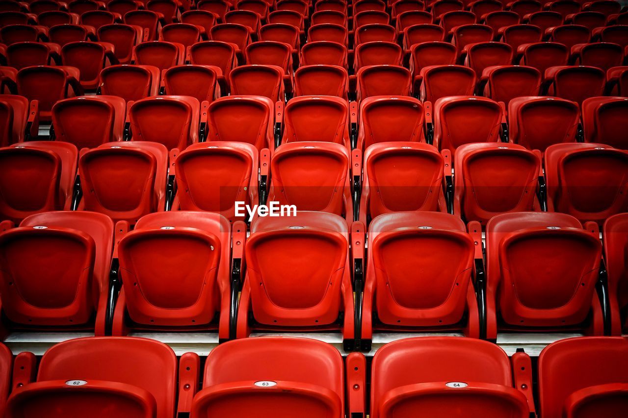 Full frame shot of empty red bleachers in stadium