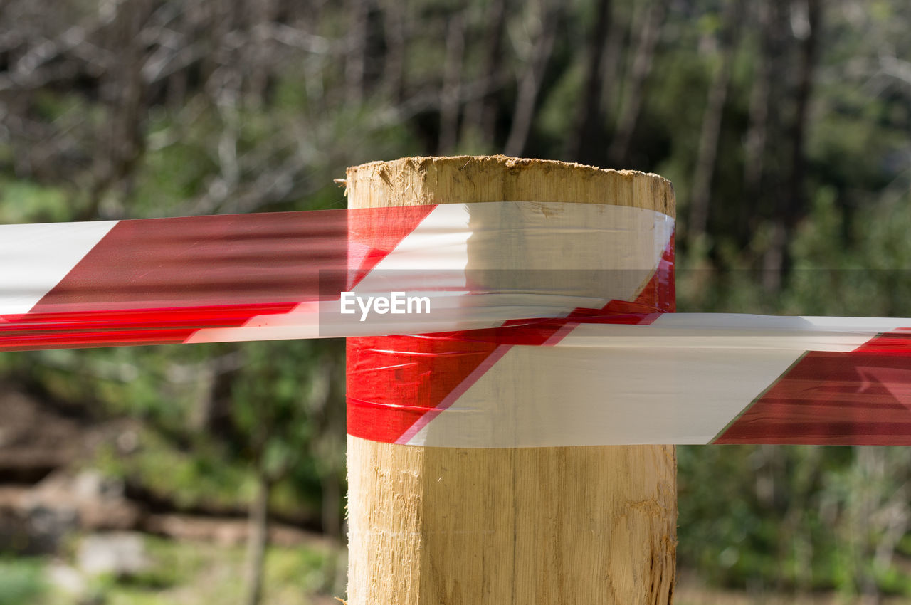 CLOSE-UP OF FLAGS ON WOODEN POST