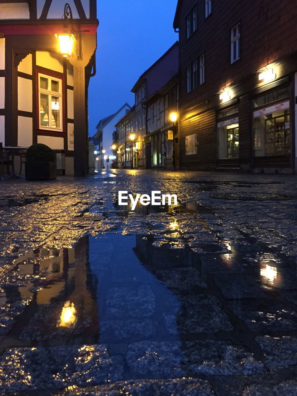 Empty road along built structures at night