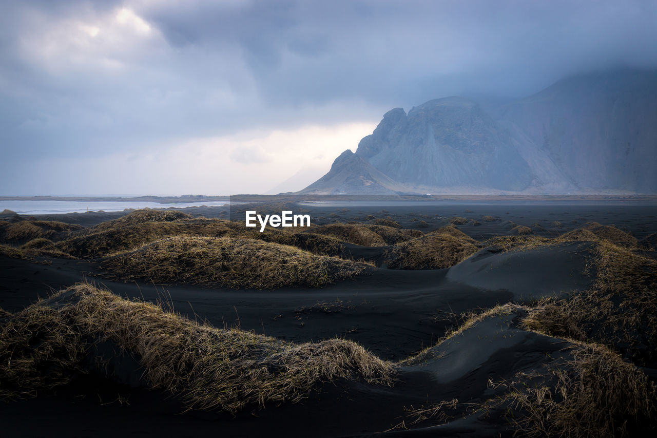 Aerial view of sea and mountains against sky