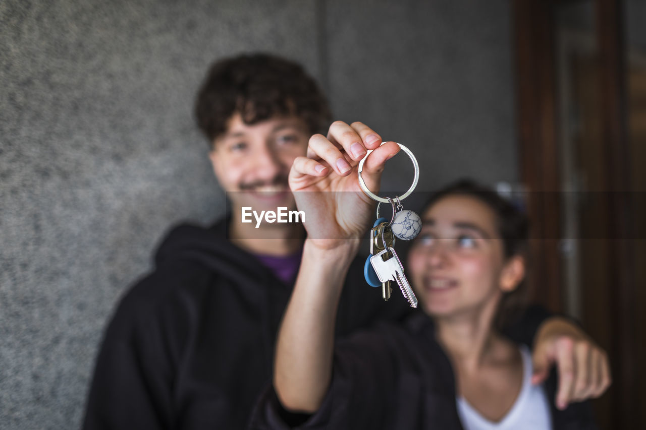 Couple showing keys to new apartment