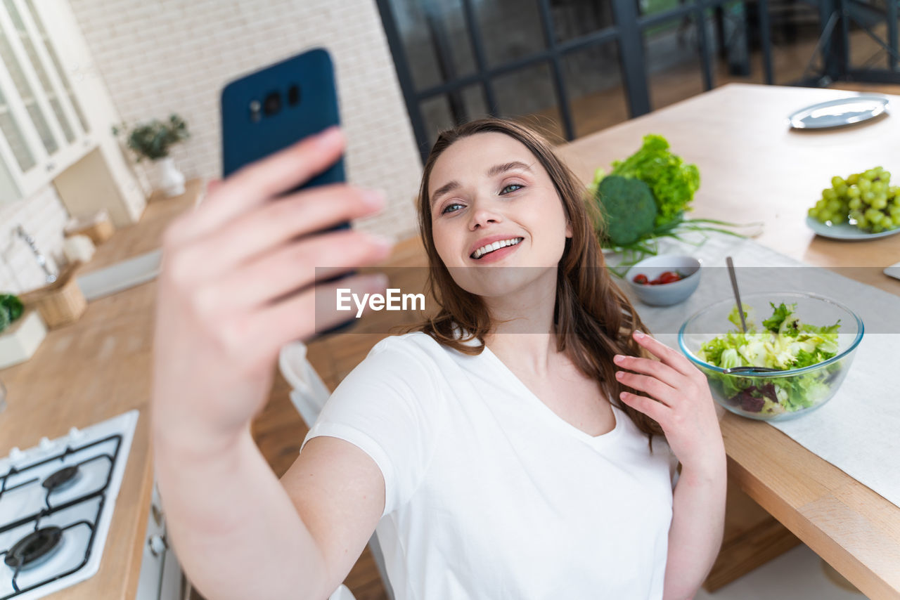 Portrait of smiling woman holding mobile phone