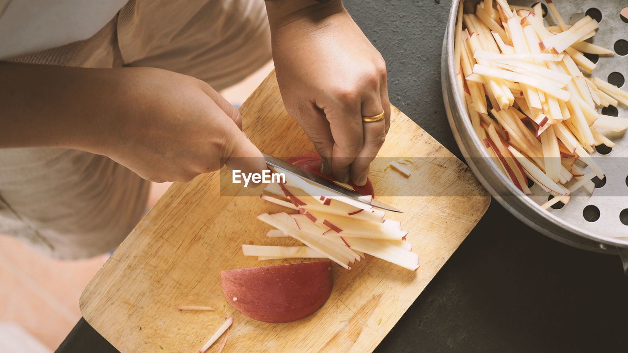 HIGH ANGLE VIEW OF WOMAN PREPARING FOOD IN KITCHEN