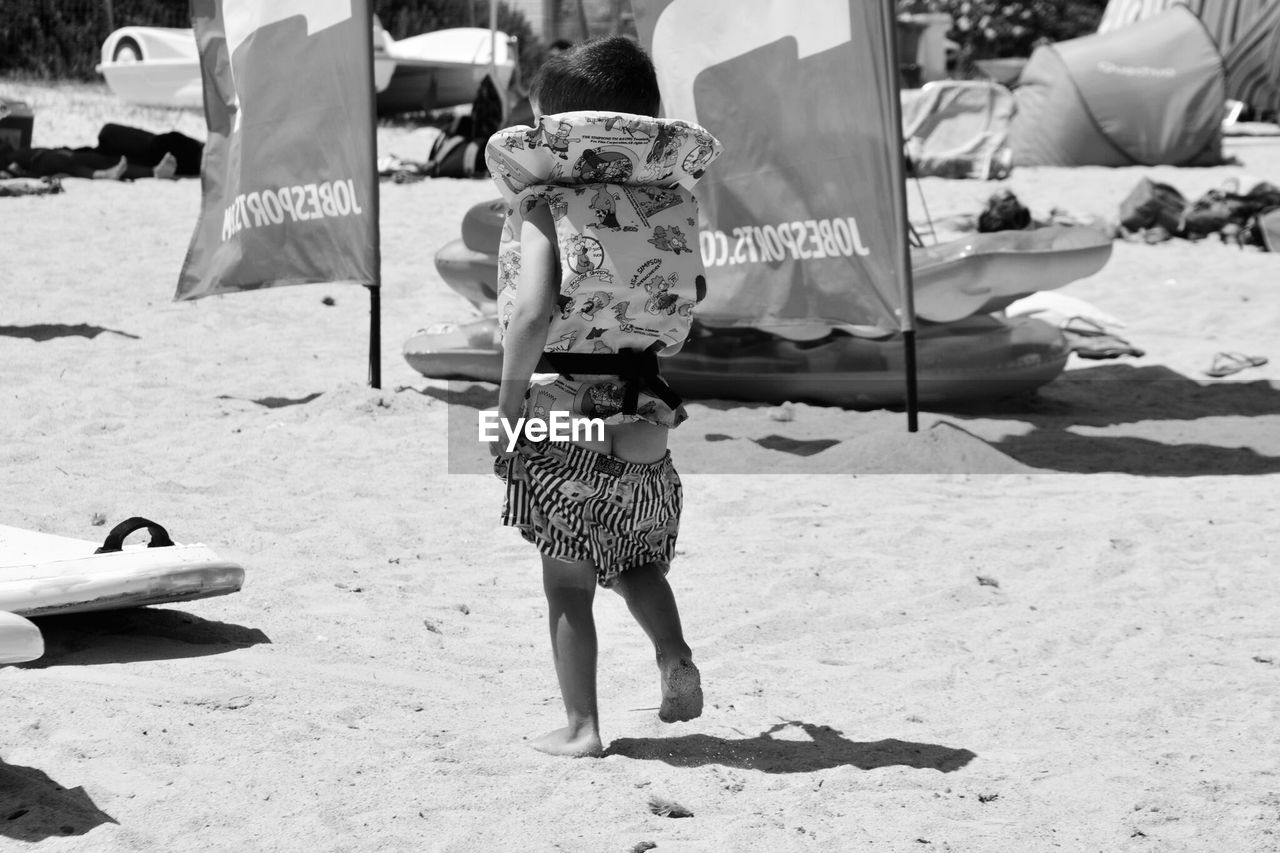 REAR VIEW OF TWO WOMEN ON BEACH