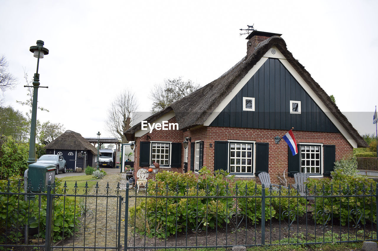 architecture, building exterior, built structure, building, house, residential district, sky, plant, nature, residential area, no people, home, street, rural area, tree, cottage, city, town, outdoors, suburb, estate, day, neighbourhood, fence, front or back yard