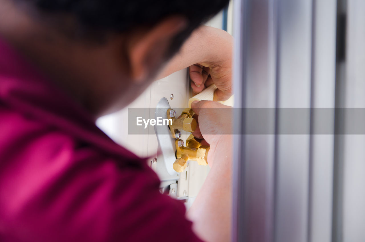 Close-up of man repairing door