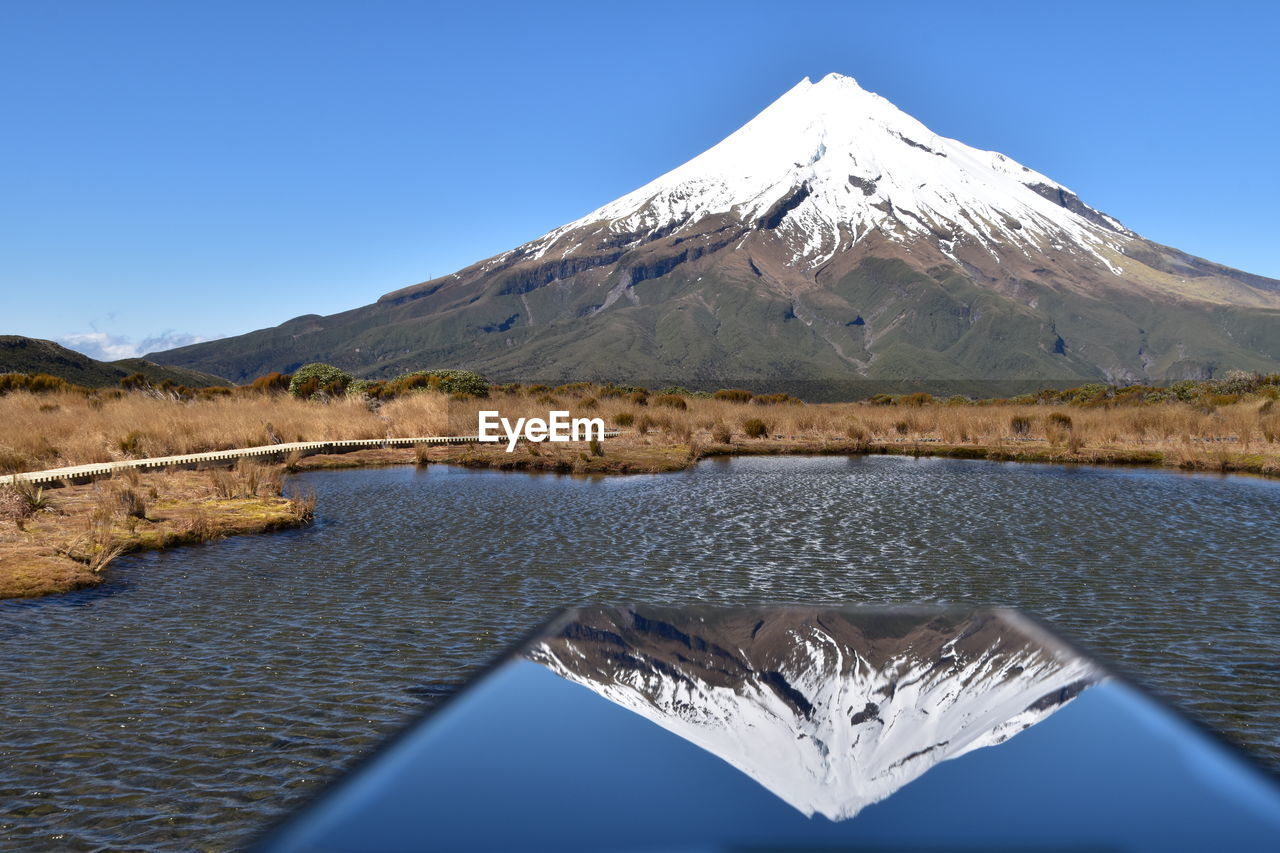 Scenic view of snowcapped mountains against clear blue sky