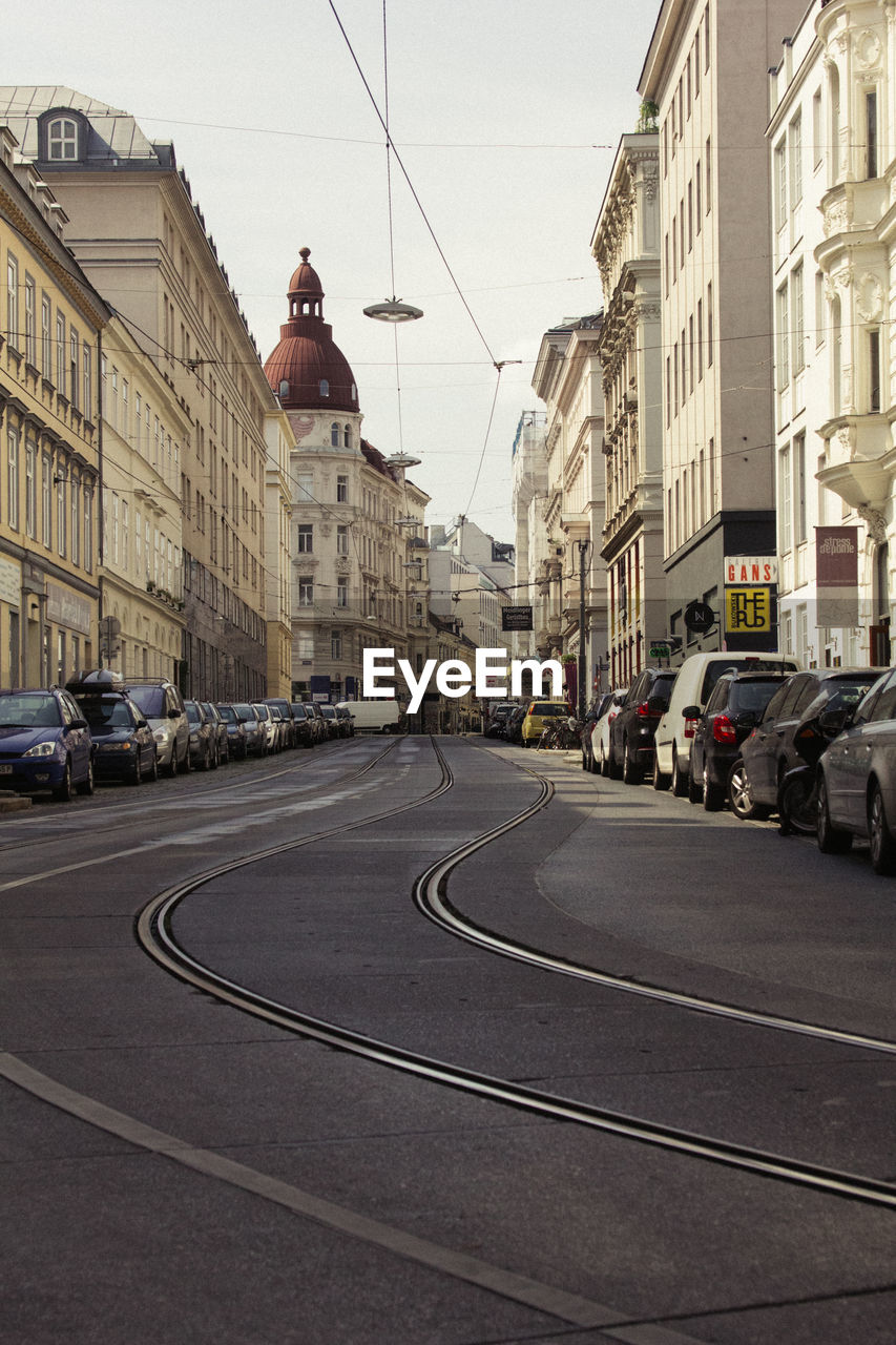 Road amidst buildings against sky