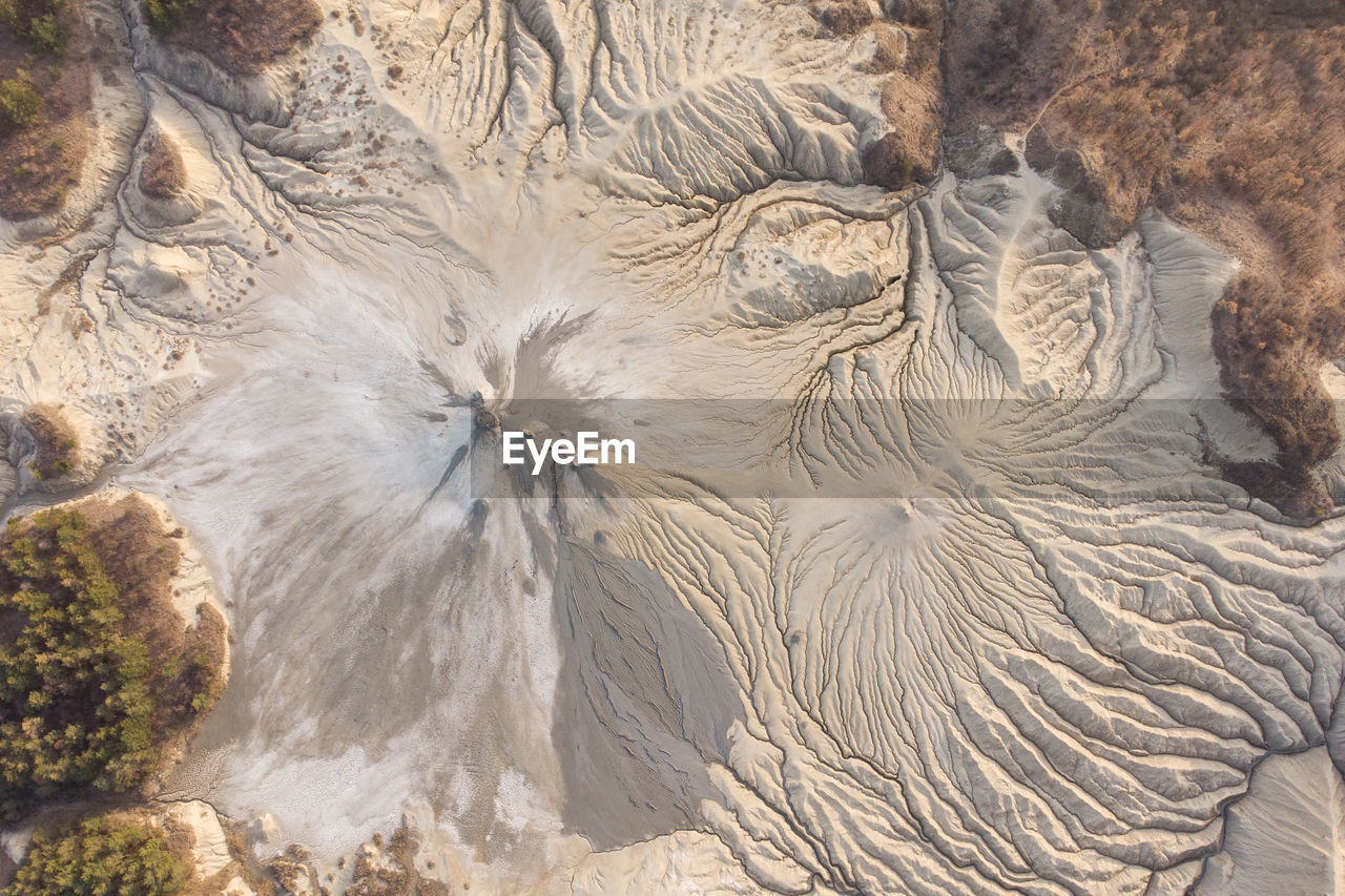 HIGH ANGLE VIEW OF ROCK FORMATION ON SHORE