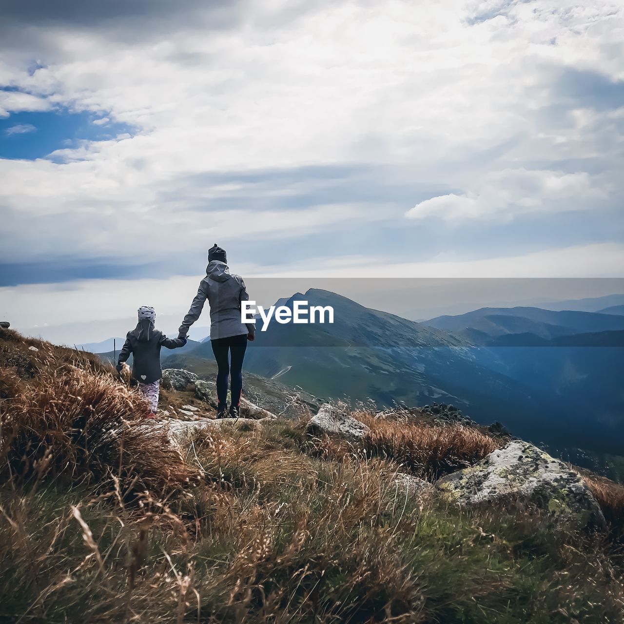 Rear view of young woman with child standing on mountain