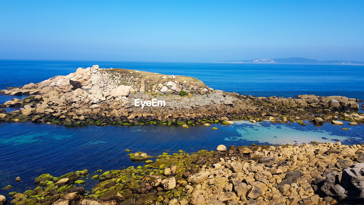 Scenic view of beach against blue sky