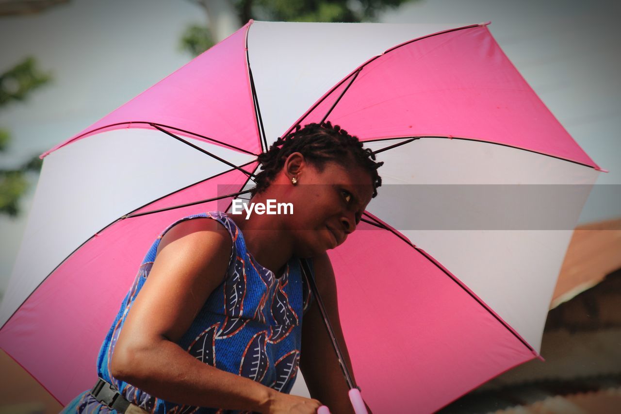 Woman with umbrella looking away outdoors