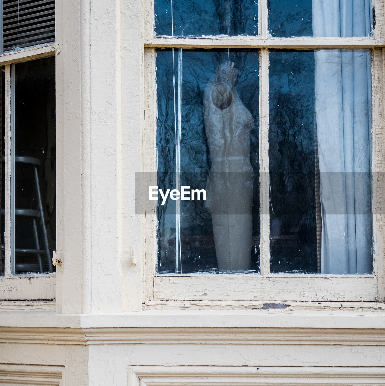 Dressmaker model seen through glass window