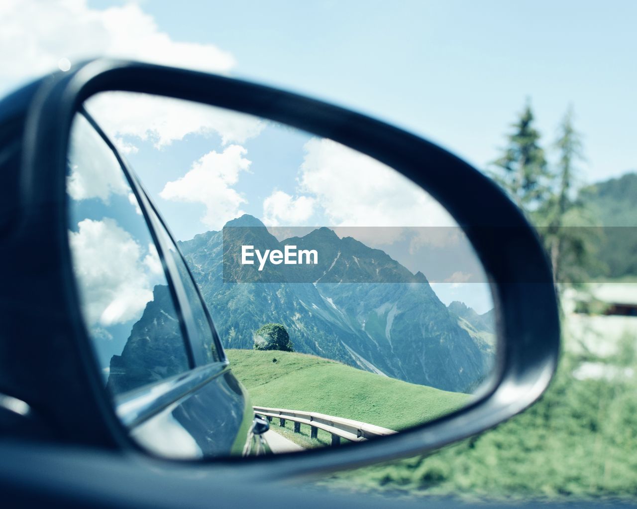 REFLECTION OF MOUNTAINS ON SIDE-VIEW MIRROR