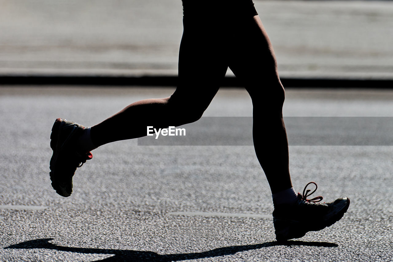 Low section of man running on street