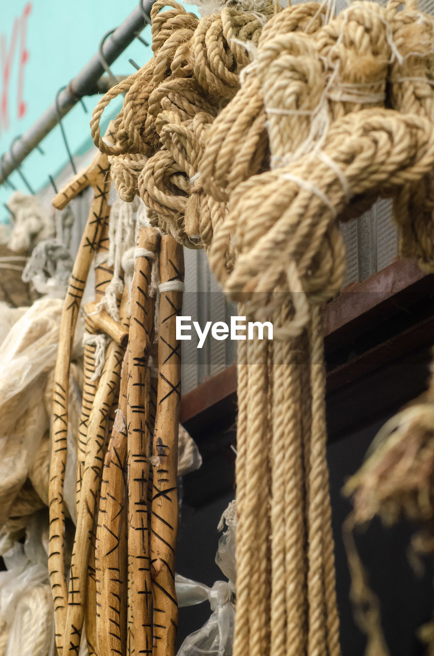 rope, strength, tied up, no people, tied knot, nautical vessel, knot, wood, day, close-up, transportation, sculpture, durability, outdoors, mode of transportation, sailing ship, pulley, focus on foreground, hanging, nature