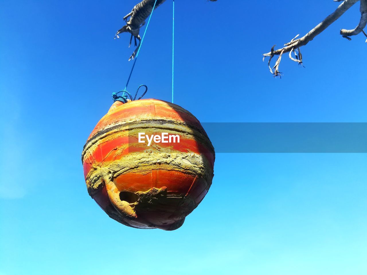 LOW ANGLE VIEW OF DECORATION HANGING AGAINST BLUE SKY