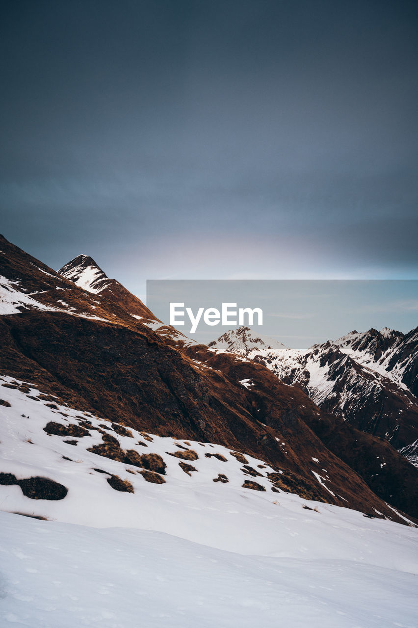 Scenic view of snow covered mountains against sky