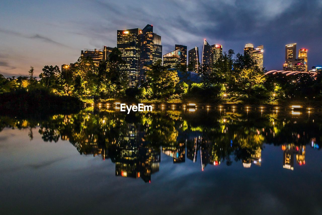 Reflection of buildings in lake at night