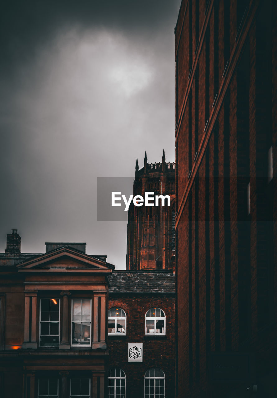 Low angle view of liverpool cathedral with other buildings in foreground