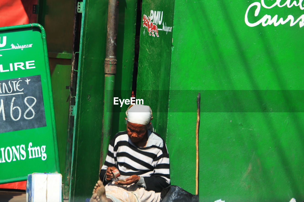 REAR VIEW OF MAN WITH TEXT ON GREEN LEAF