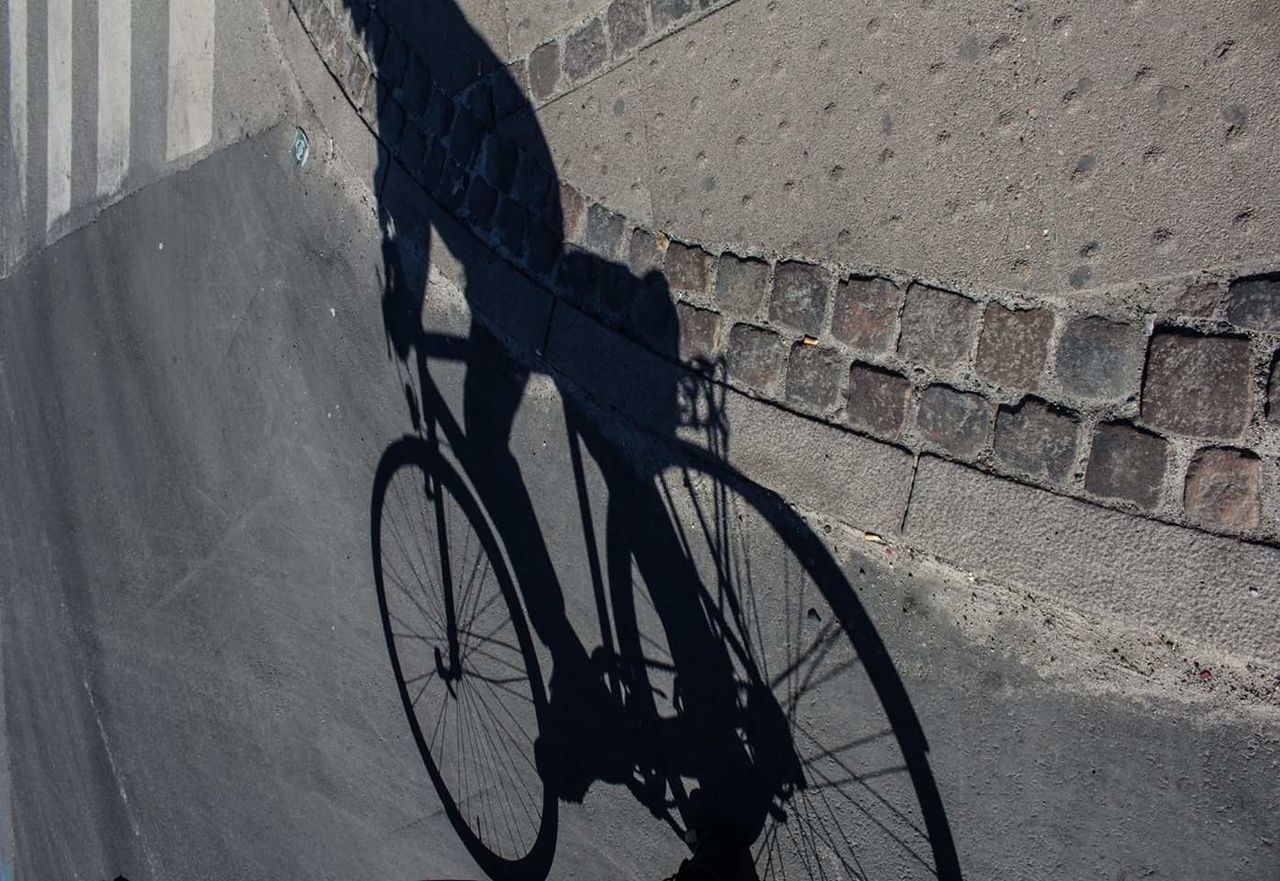 HIGH ANGLE VIEW OF BICYCLE SHADOW ON CITY